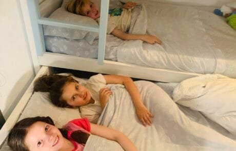 Carolina y sus hermanos, a la hora de dormir, en las literas de su habitación.