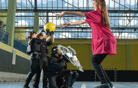 Fotografía del calendario ELA 2024: Carolina lanza un balón a agentes de la Guardia Civil en un pabellón.