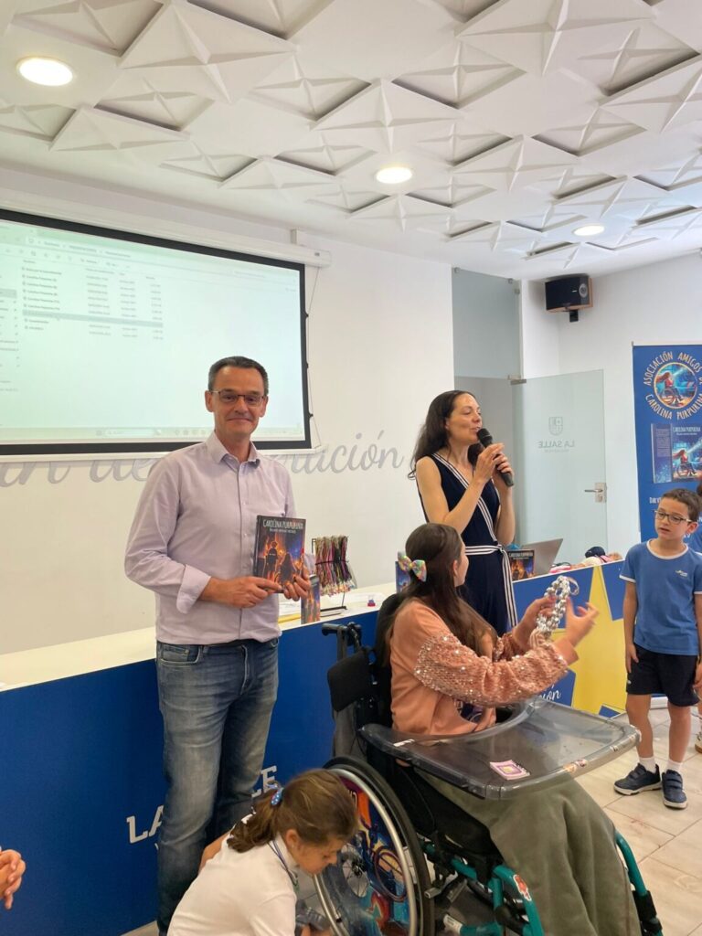 Buchvorstellung in La Salle Valladolid: Laura spricht ins Mikrofon, während den Schülern das Buch gezeigt wird.
