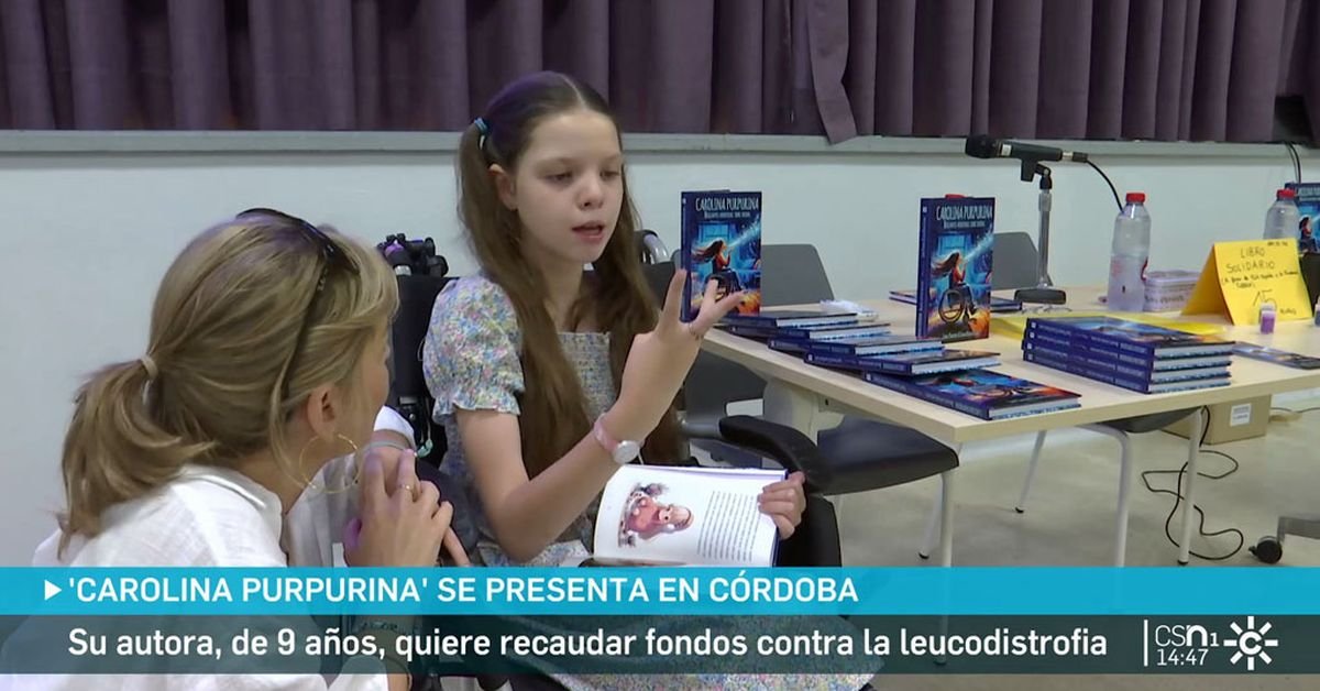 Reportaje de Canal Sur en Córdoba: una niña sentada, con el libro abierto, conversa con una mujer; detrás, la mesa con ejemplares del libro.