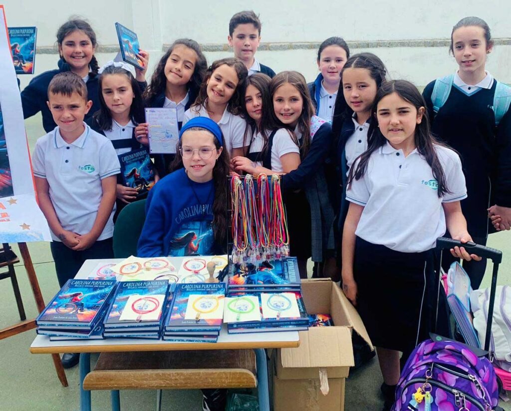Visite à l’école Presentación de María : une fillette, derrière la table de livres et de bracelets, entourée d’élèves en uniforme.